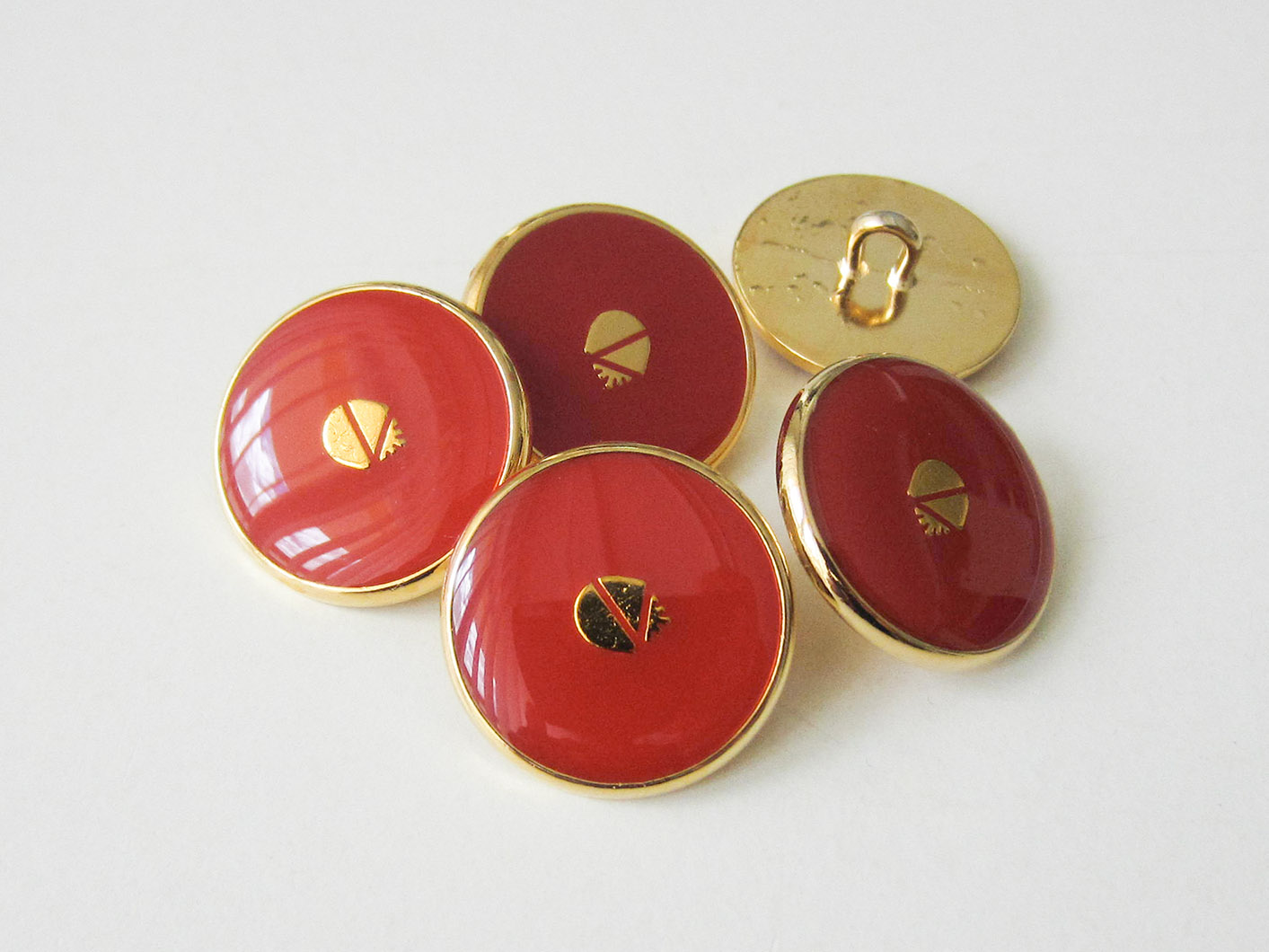 Glänzend rot goldfarbener Metall Knopf mit Wappen