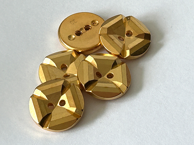 www.knopfparadies.de - k261go - Goldfarbener Kunststoffknopf mit stufenartig facettierter Oberfläche