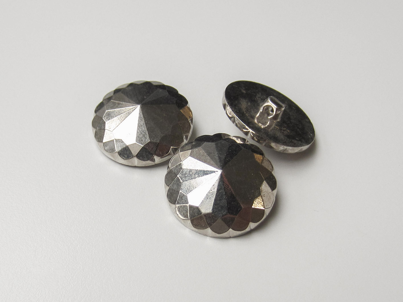Facettierte metallic silberfarbene Knöpfe wie aus Glas