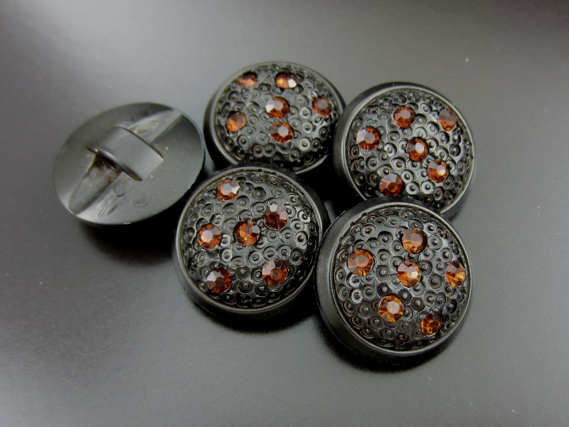Schwarzbrauner Knopf mit sechs Glitzersteinen