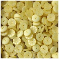 Gelb perlmuttartig schimmernder Knopf m. Strahlenkranz Gelb perlmuttartig schimmernder Knopf m. Strahlenkranz